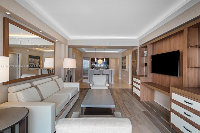 living room with a tray ceiling and hardwood / wood-style floors