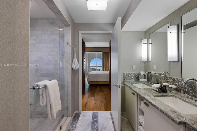 bathroom with large vanity, dual sinks, a shower with door, and tile flooring