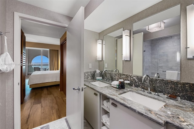 bathroom featuring vanity with extensive cabinet space, double sink, and hardwood / wood-style flooring