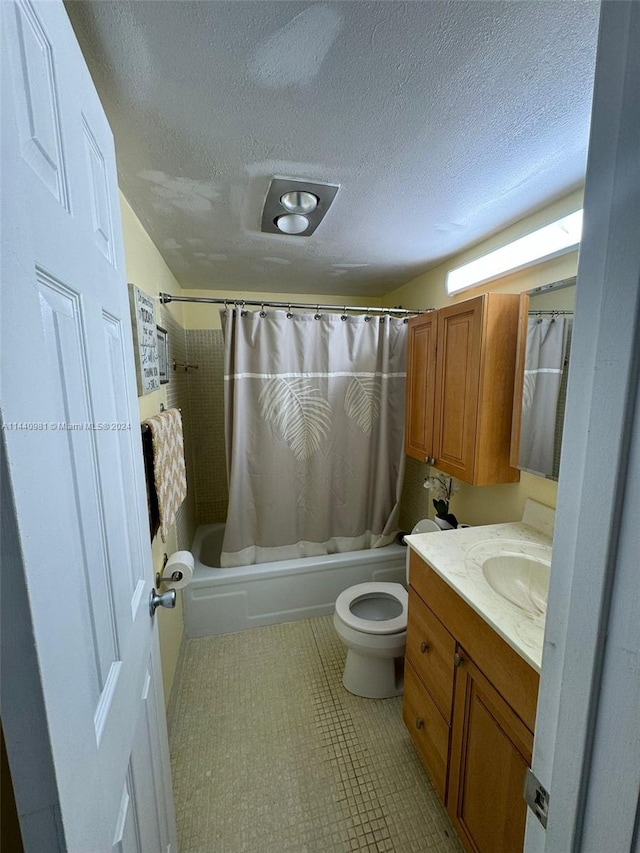 full bathroom featuring vanity, a textured ceiling, tile patterned flooring, shower / tub combo with curtain, and toilet