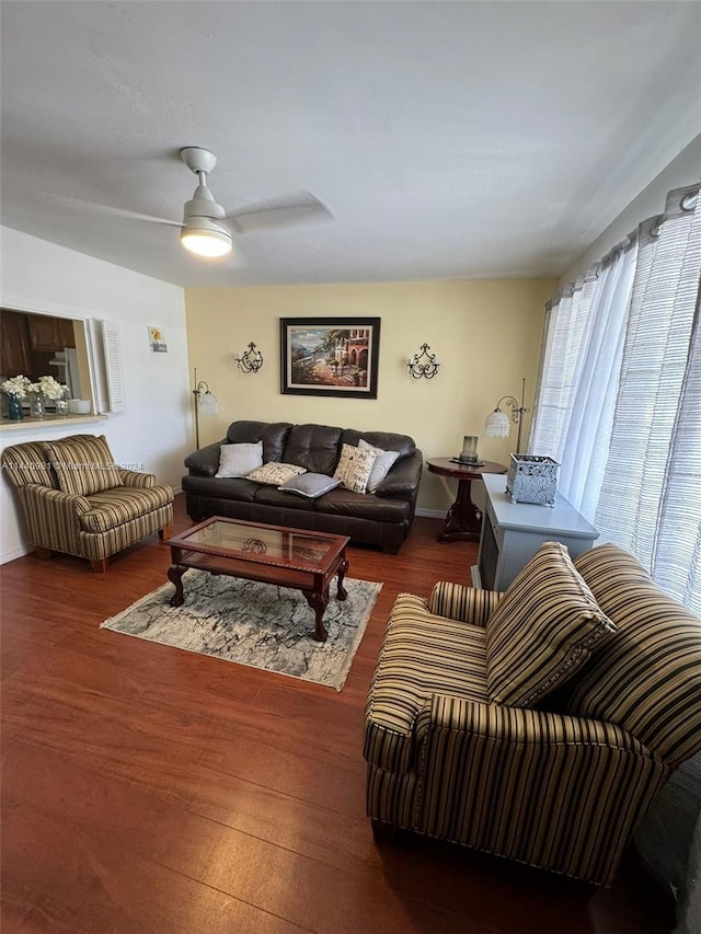 living room with ceiling fan and dark wood-type flooring