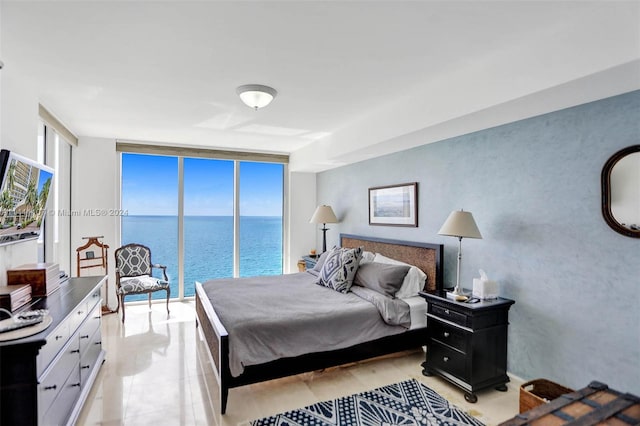 bedroom with floor to ceiling windows and a water view