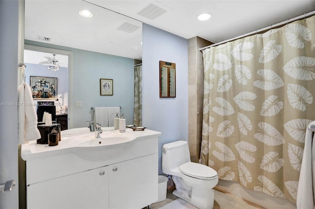 bathroom with vanity with extensive cabinet space, toilet, tile floors, and ceiling fan