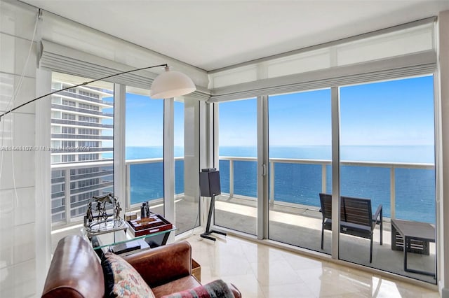 sunroom featuring a wealth of natural light and a water view