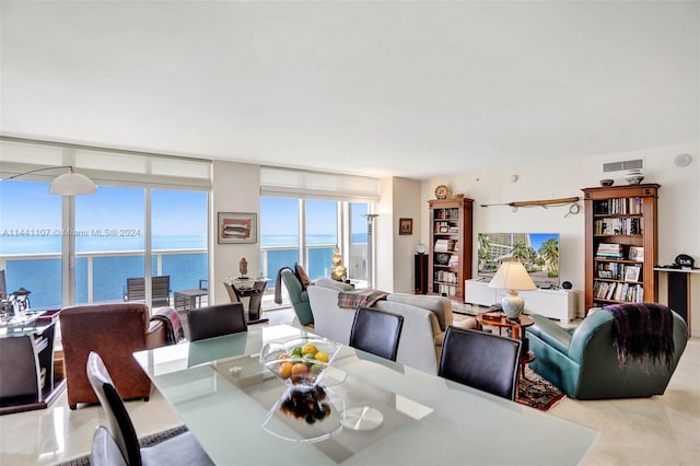 dining area featuring expansive windows and a water view