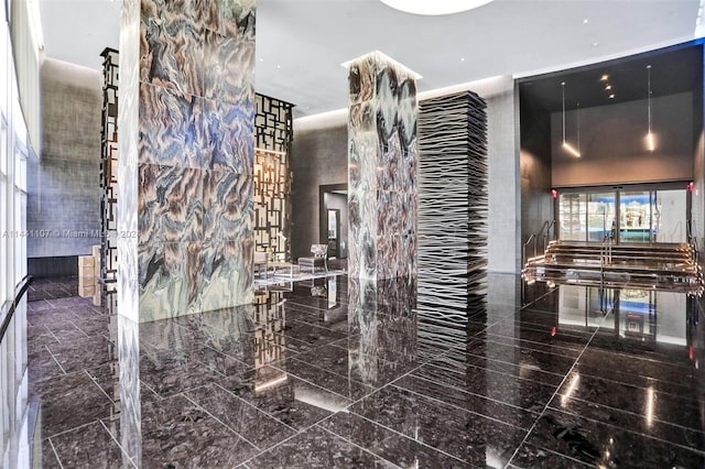 interior space featuring stone countertops, dark tile floors, and decorative light fixtures