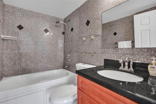 full bathroom featuring tiled shower / bath combo, toilet, and vanity