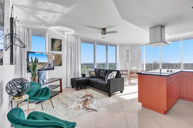 tiled living room featuring ceiling fan and floor to ceiling windows