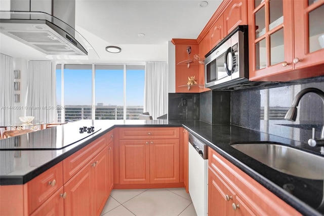 kitchen with white dishwasher, light tile floors, tasteful backsplash, dark stone countertops, and sink