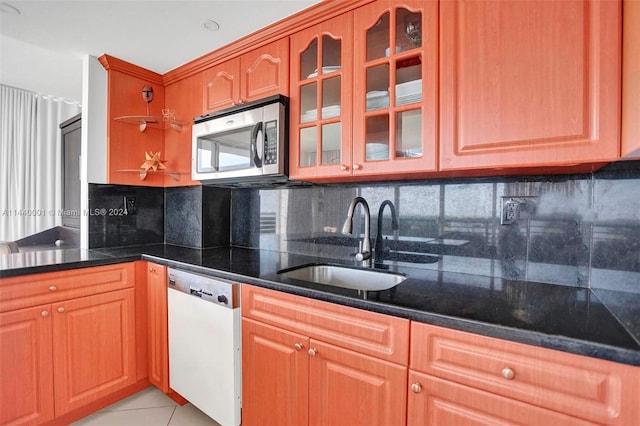 kitchen with sink, white dishwasher, tasteful backsplash, and light tile floors