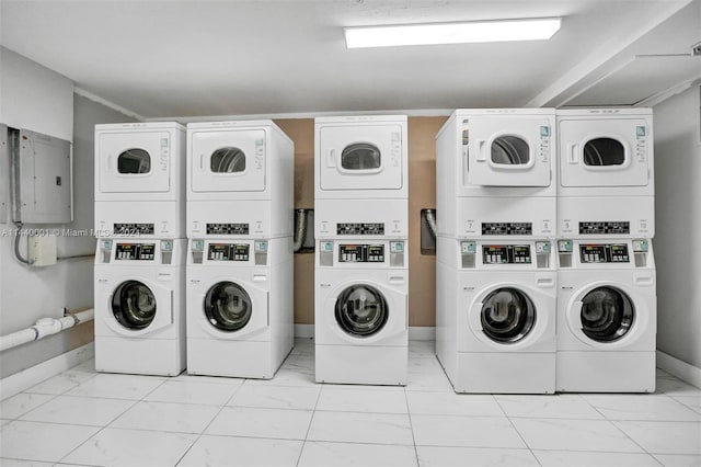 washroom featuring independent washer and dryer, stacked washer / drying machine, and light tile floors