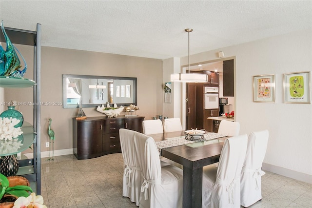 tiled dining space with a textured ceiling