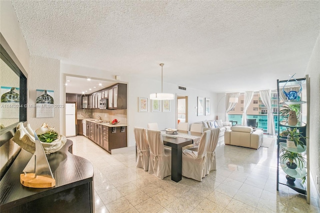 tiled dining area featuring a textured ceiling