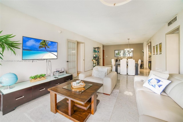 living room featuring light tile flooring and a notable chandelier