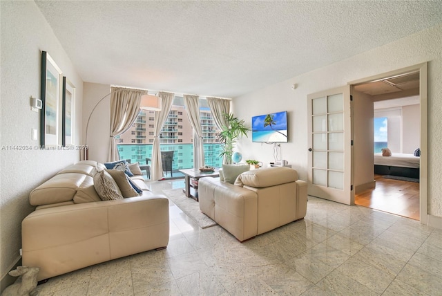 tiled living room featuring plenty of natural light and a textured ceiling