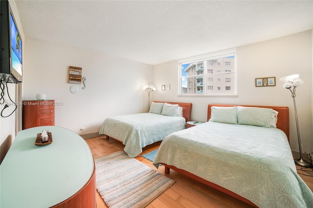 bedroom featuring a textured ceiling and light hardwood / wood-style floors