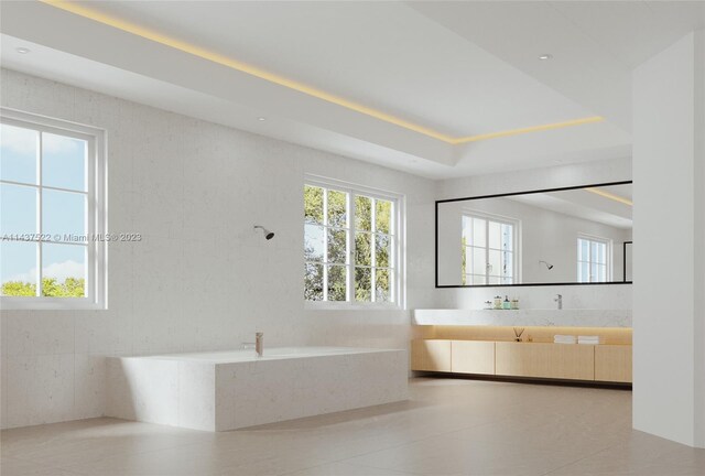 bathroom featuring tiled tub, vanity, and tile flooring