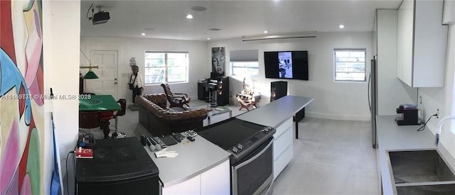 kitchen featuring light tile floors, white cabinetry, and sink