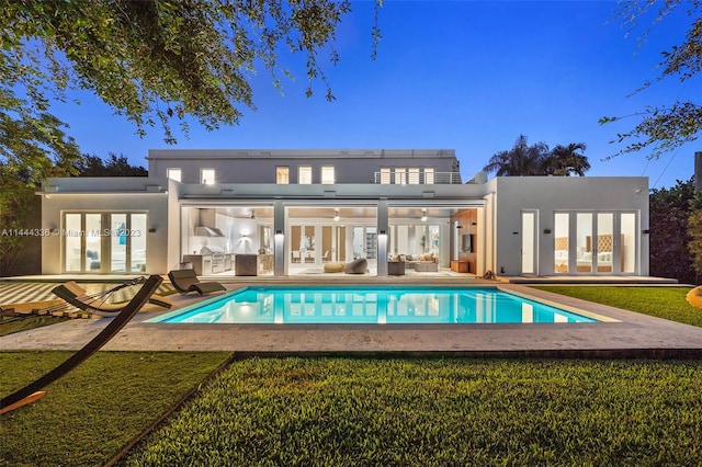 view of pool with french doors, a yard, and a patio