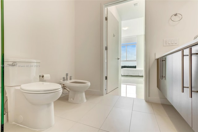 bathroom featuring toilet, a bidet, and tile flooring