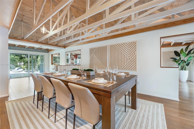 dining area featuring high vaulted ceiling, light wood-type flooring, beamed ceiling, and wooden ceiling