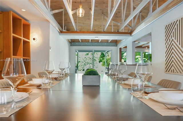 dining room featuring beamed ceiling and a towering ceiling