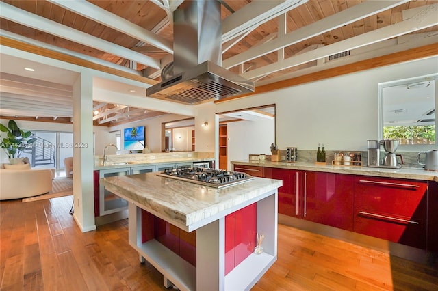 kitchen featuring light wood-type flooring, island exhaust hood, and beamed ceiling