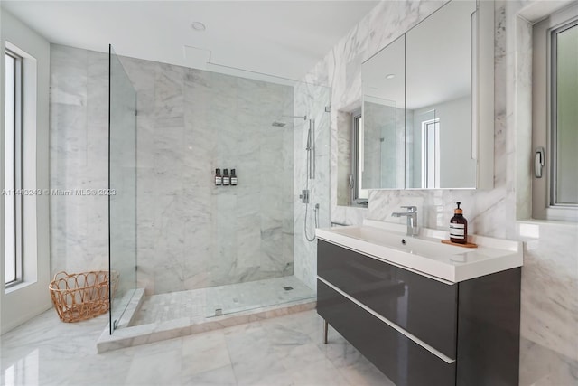 bathroom with a shower with door, tile patterned flooring, vanity, and tile walls