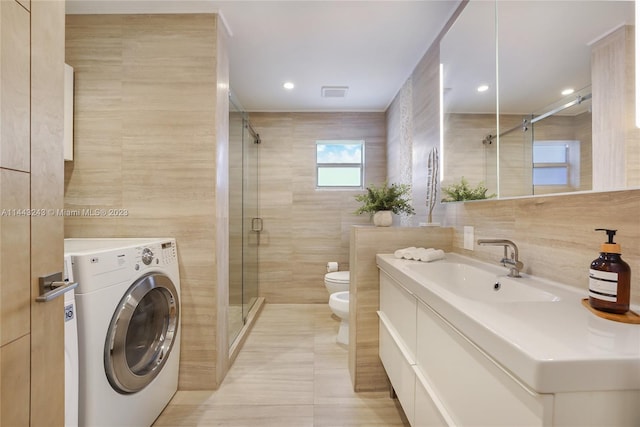 bathroom featuring a bidet, tile patterned flooring, washer / clothes dryer, tile walls, and toilet