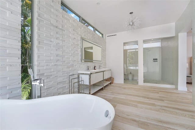 bathroom featuring radiator, a bath, vanity, and wood-type flooring