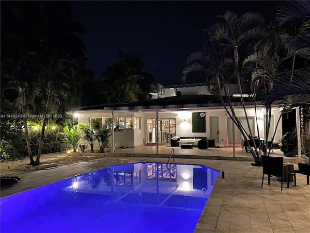 pool at twilight with a patio area