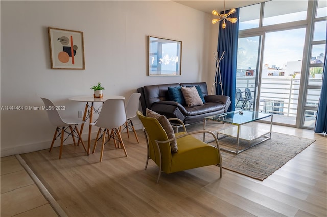 living room with an inviting chandelier, light hardwood / wood-style floors, and expansive windows