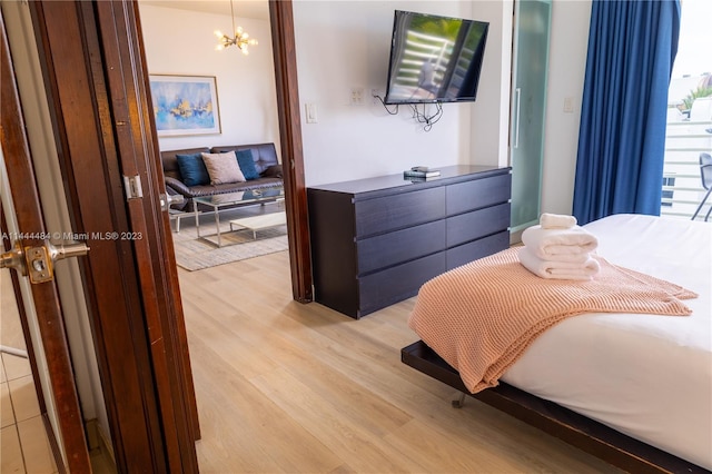 bedroom featuring a notable chandelier and light hardwood / wood-style flooring