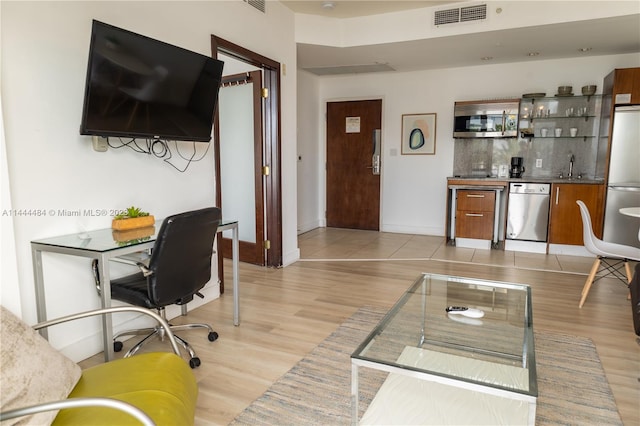 living room with sink and light wood-type flooring