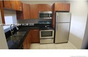 kitchen with stainless steel appliances, light tile floors, and sink