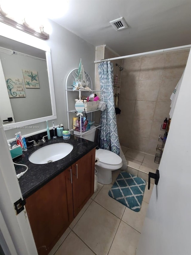 bathroom featuring vanity, tile floors, toilet, and walk in shower