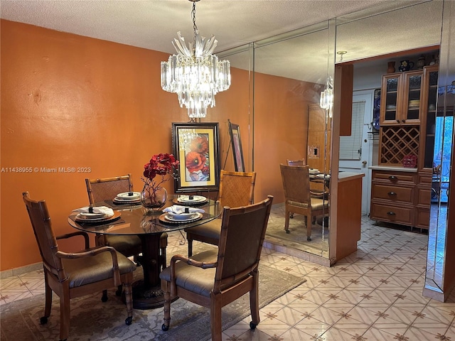 tiled dining space with a chandelier and a textured ceiling