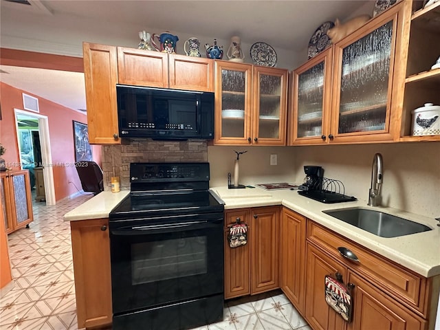 kitchen with light tile flooring, black appliances, and sink