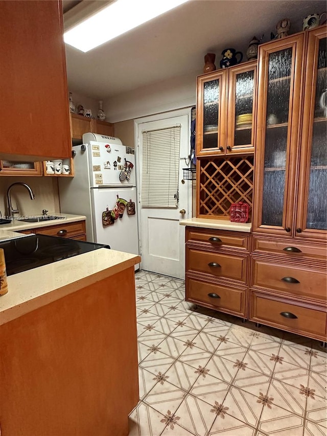 kitchen featuring white fridge, light tile floors, and sink