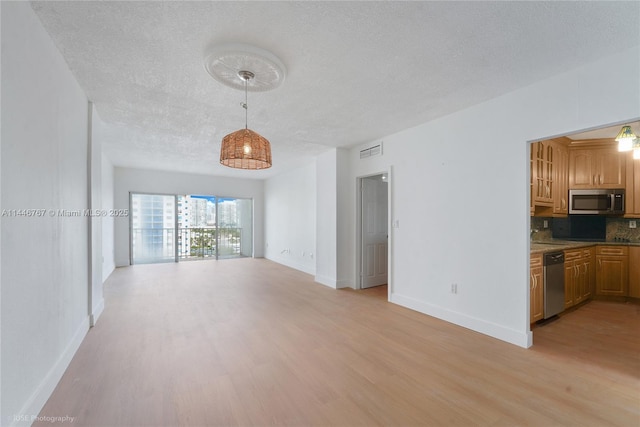 unfurnished living room featuring a textured ceiling and light hardwood / wood-style flooring