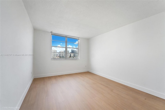 empty room featuring light hardwood / wood-style floors and a textured ceiling