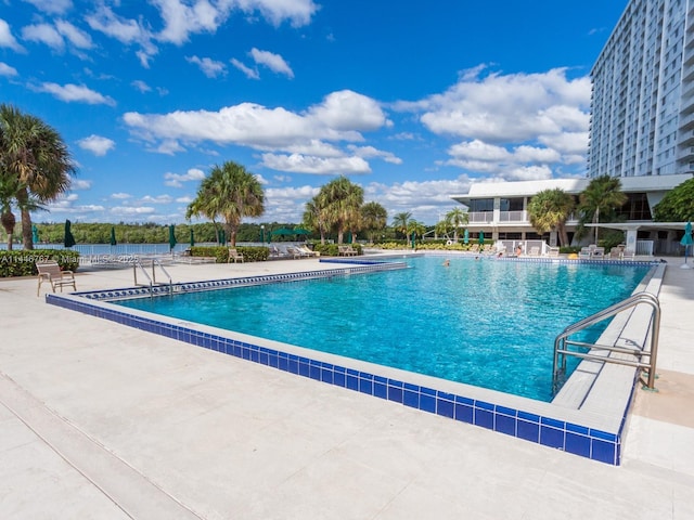 view of swimming pool featuring a patio area and a water view