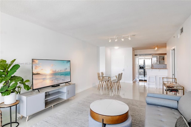 living room with rail lighting and light tile flooring