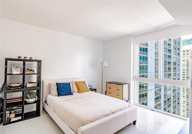 bedroom with light tile floors and multiple windows