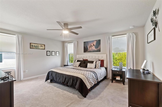 carpeted bedroom featuring a textured ceiling and ceiling fan