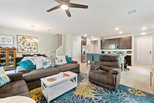 tiled living room with ceiling fan with notable chandelier