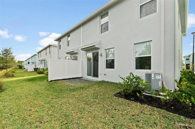 back of property featuring a yard and central AC unit