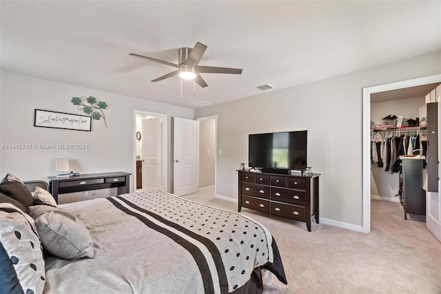 carpeted bedroom featuring a spacious closet, a closet, and ceiling fan