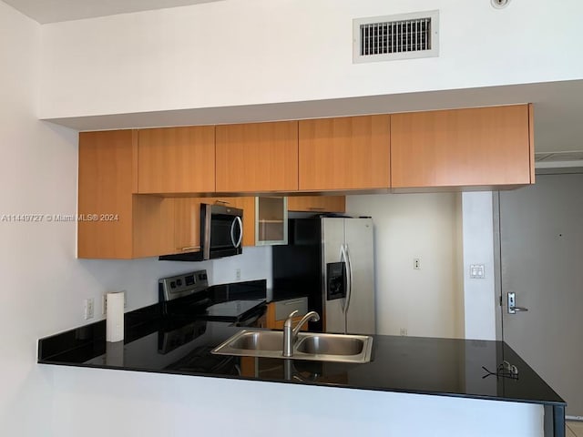 kitchen featuring kitchen peninsula, appliances with stainless steel finishes, and sink