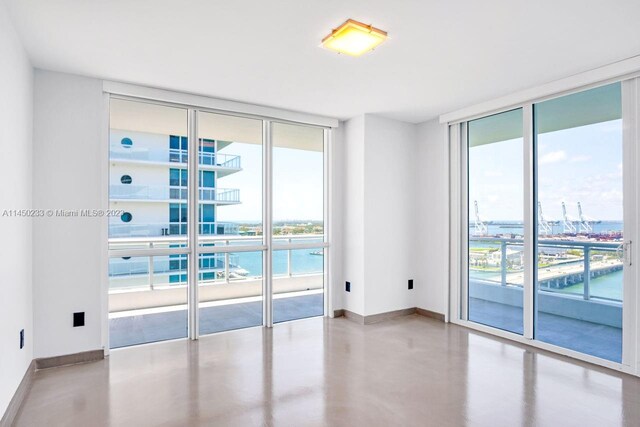 unfurnished room featuring concrete floors and a wall of windows